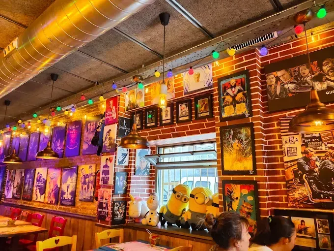 Un restaurante con una pared de ladrillos y muchos cuadros en ella.