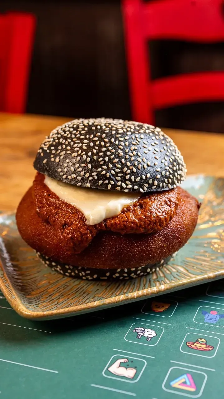 Un primer plano de una hamburguesa en un plato sobre una mesa.