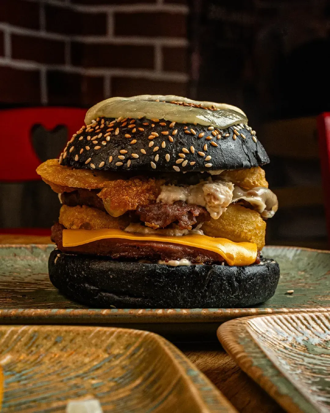Un primer plano de una hamburguesa en un plato sobre una mesa.
