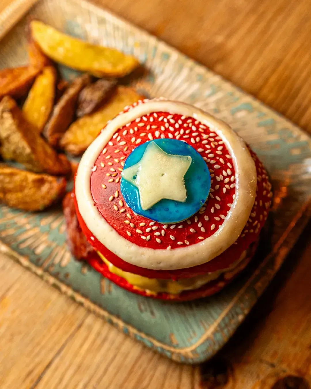 Una hamburguesa del Capitán América con papas fritas en un plato.