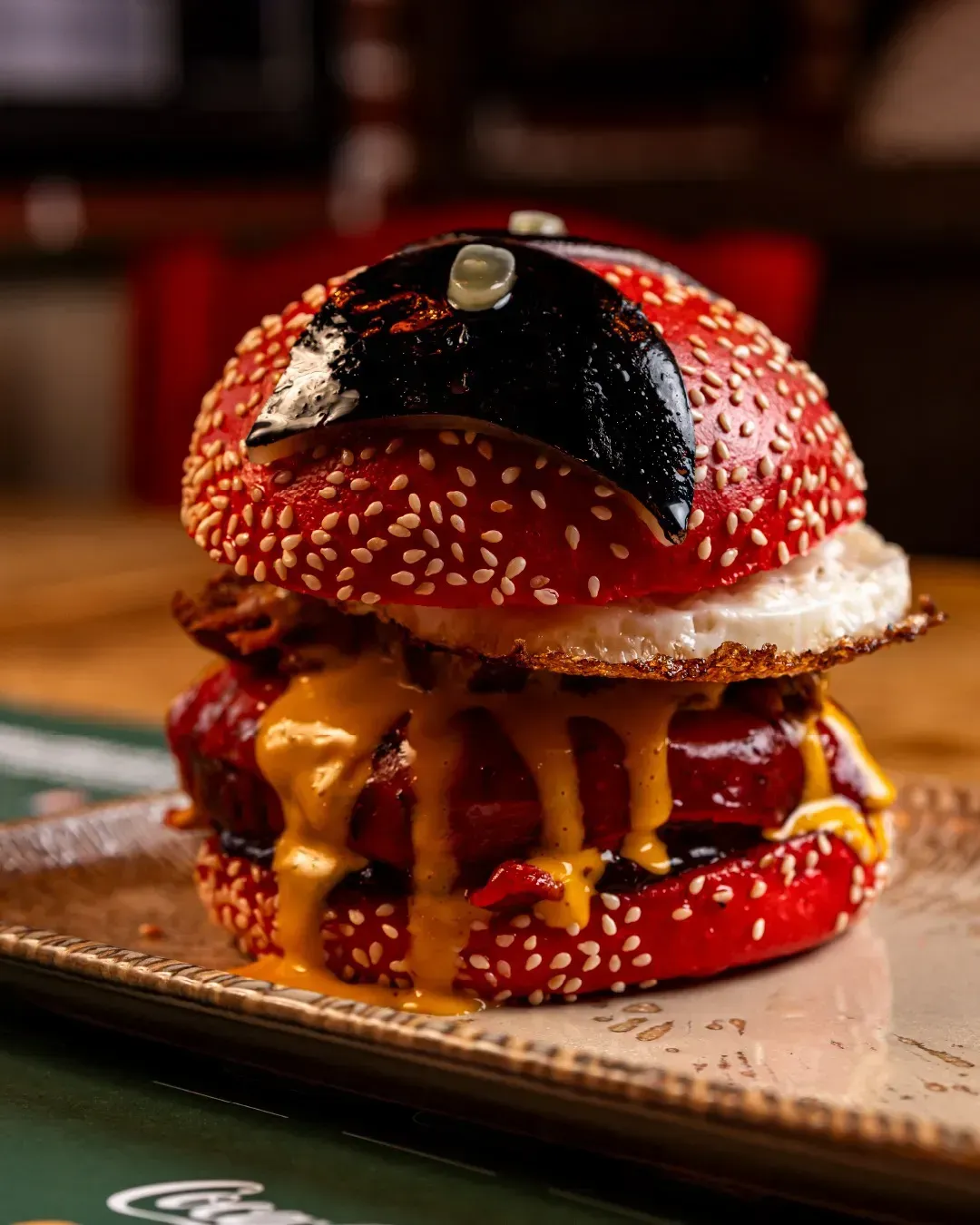 Un primer plano de una hamburguesa en un plato sobre una mesa.