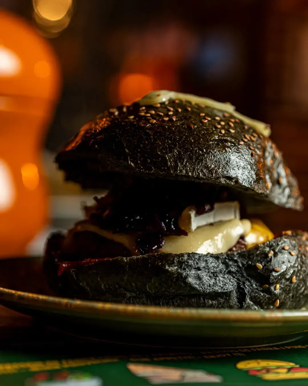 Un primer plano de una hamburguesa en un plato sobre una mesa.