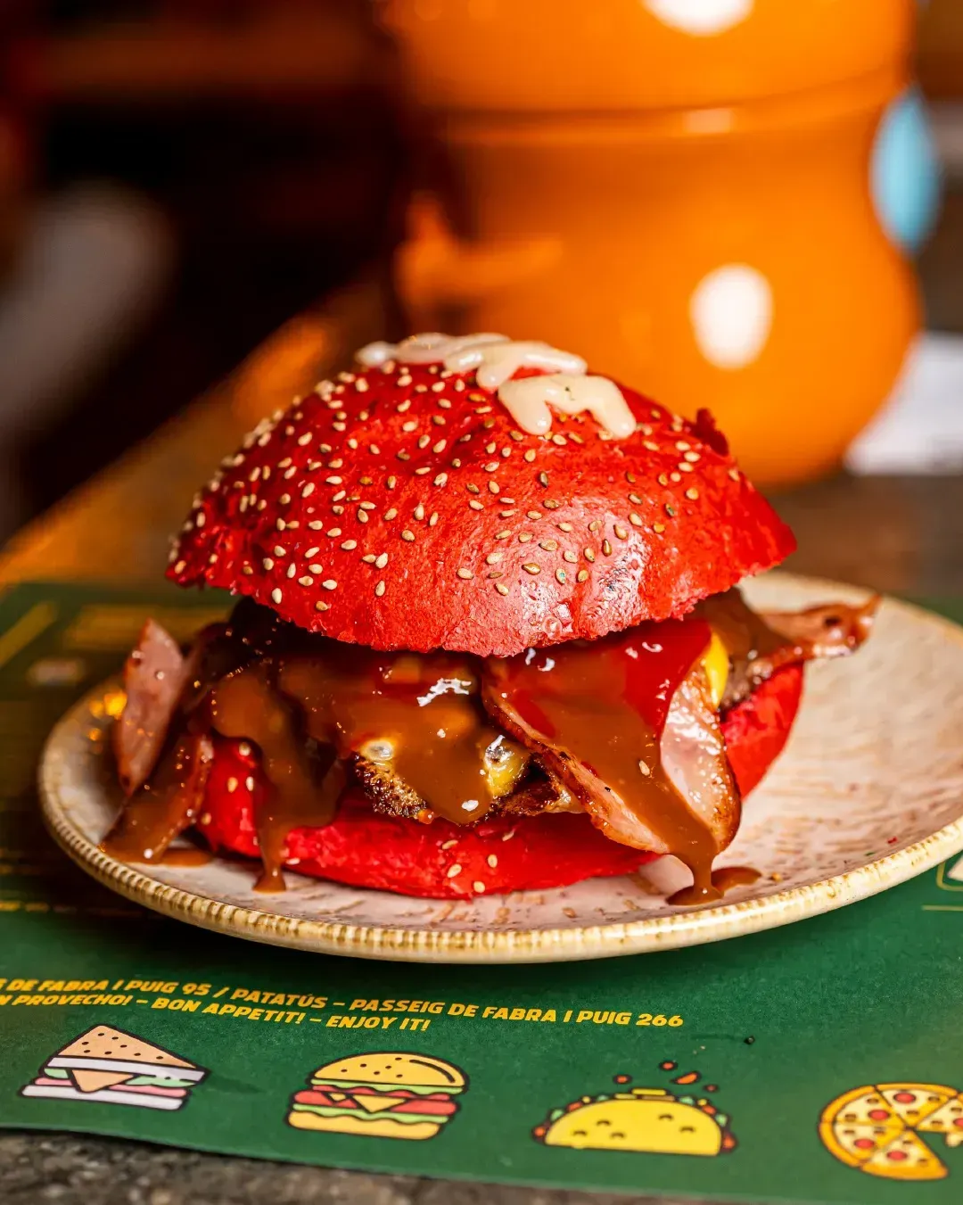 Un primer plano de una hamburguesa roja en un plato sobre una mesa.