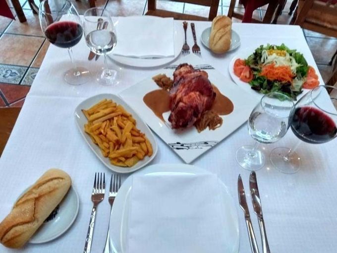 Una mesa cubierta con platos de comida y copas de vino.