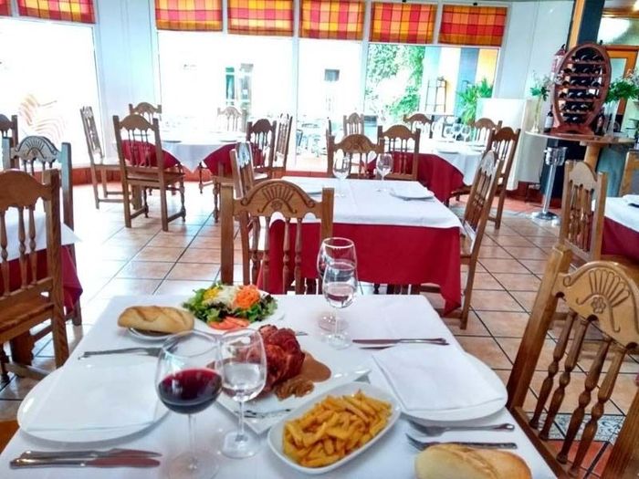 Un restaurante con platos de comida y copas de vino.