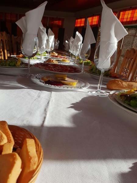 Una mesa con platos de comida y copas de vino encima.