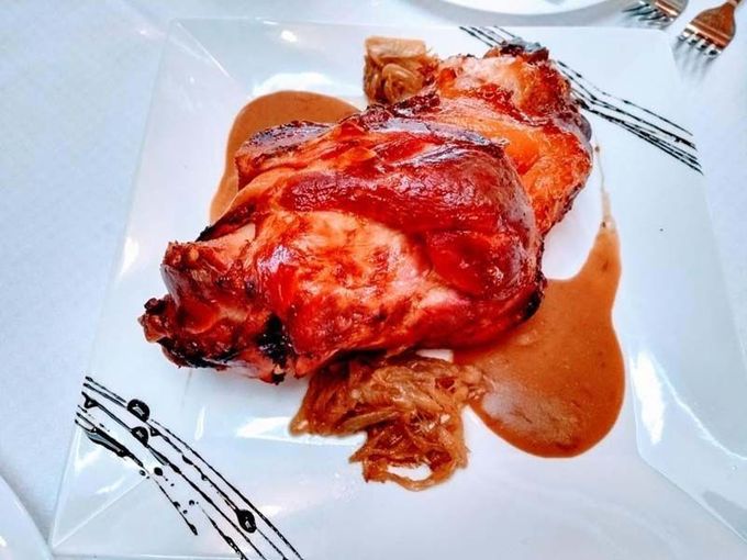 Un plato blanco cubierto con un trozo de carne y salsa.