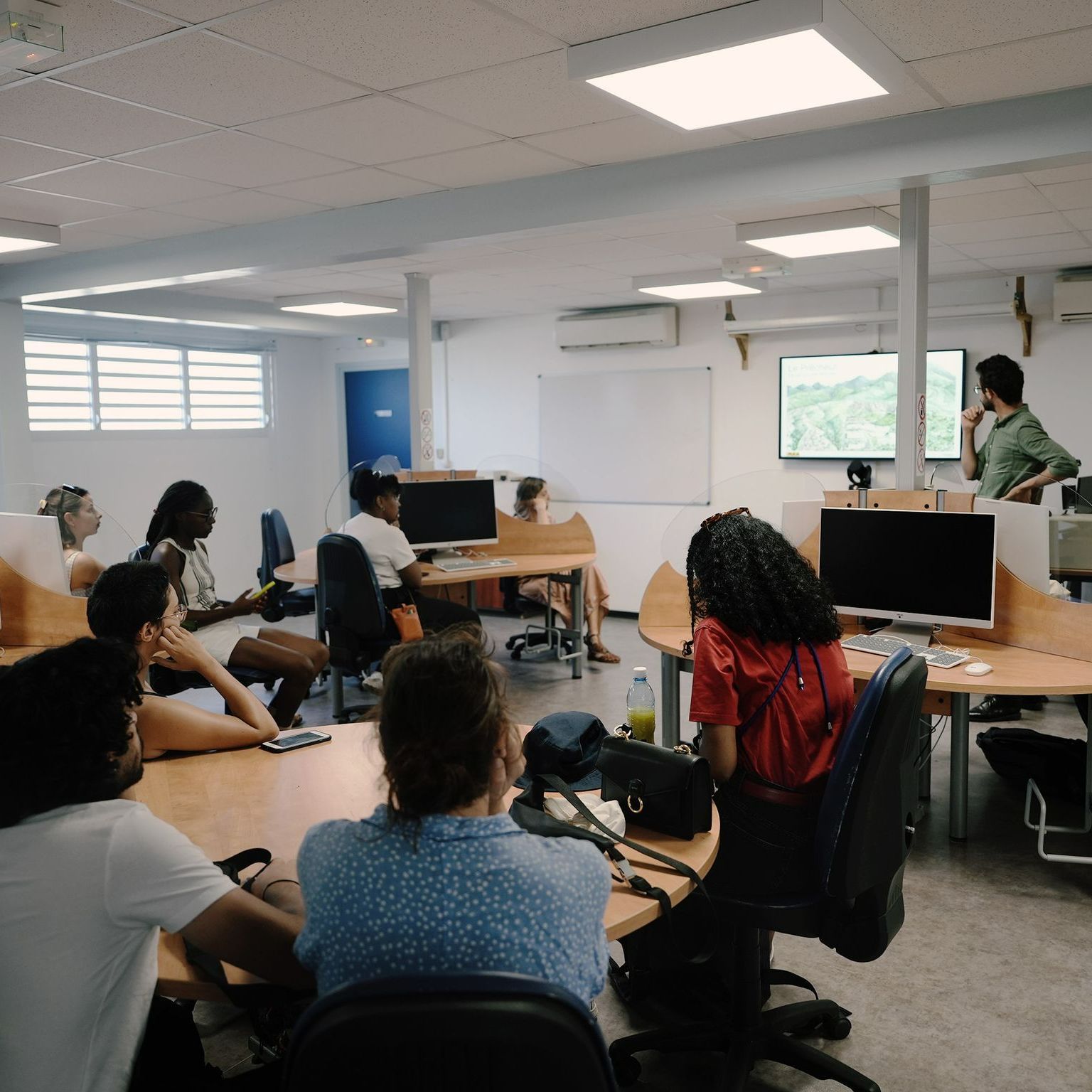 Des personnes dans une salle devant un écran.