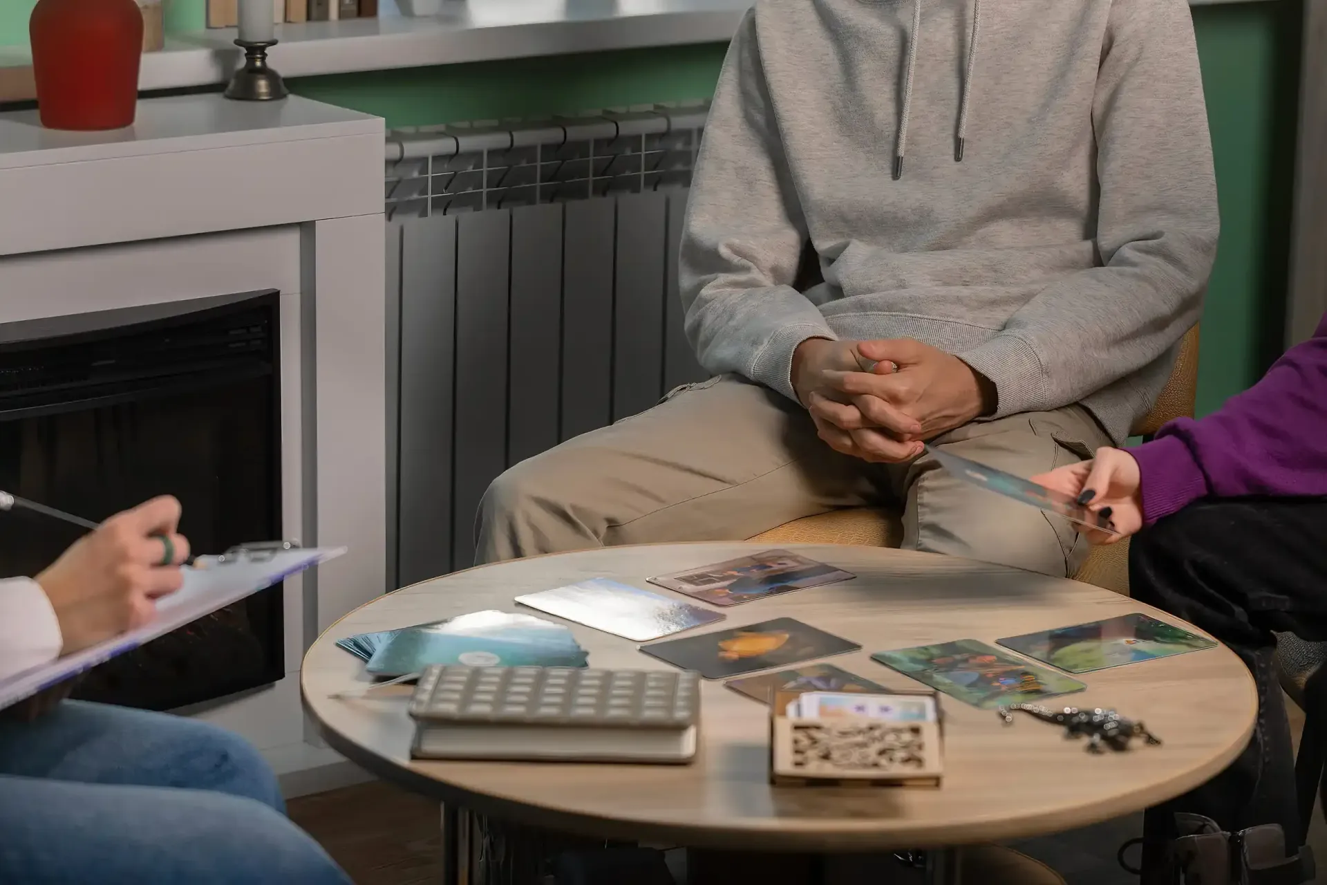Tres personas están sentadas alrededor de una mesa circular en una habitación acogedora,