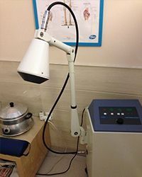 Lámpara médica blanca con panel de control sobre una mesa en una habitación de la clínica.