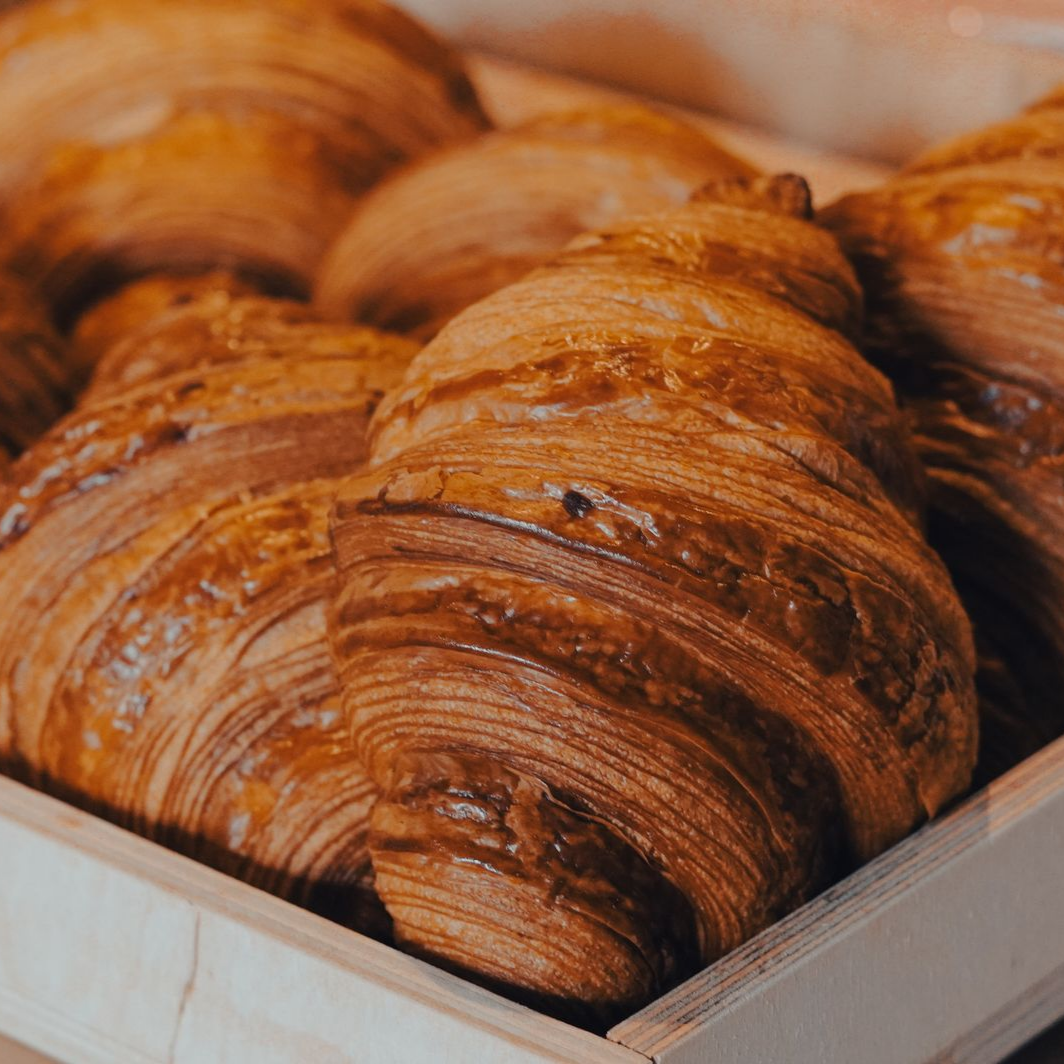 Plateau de croissants dorés dans la vitrine d’une boulangerie
