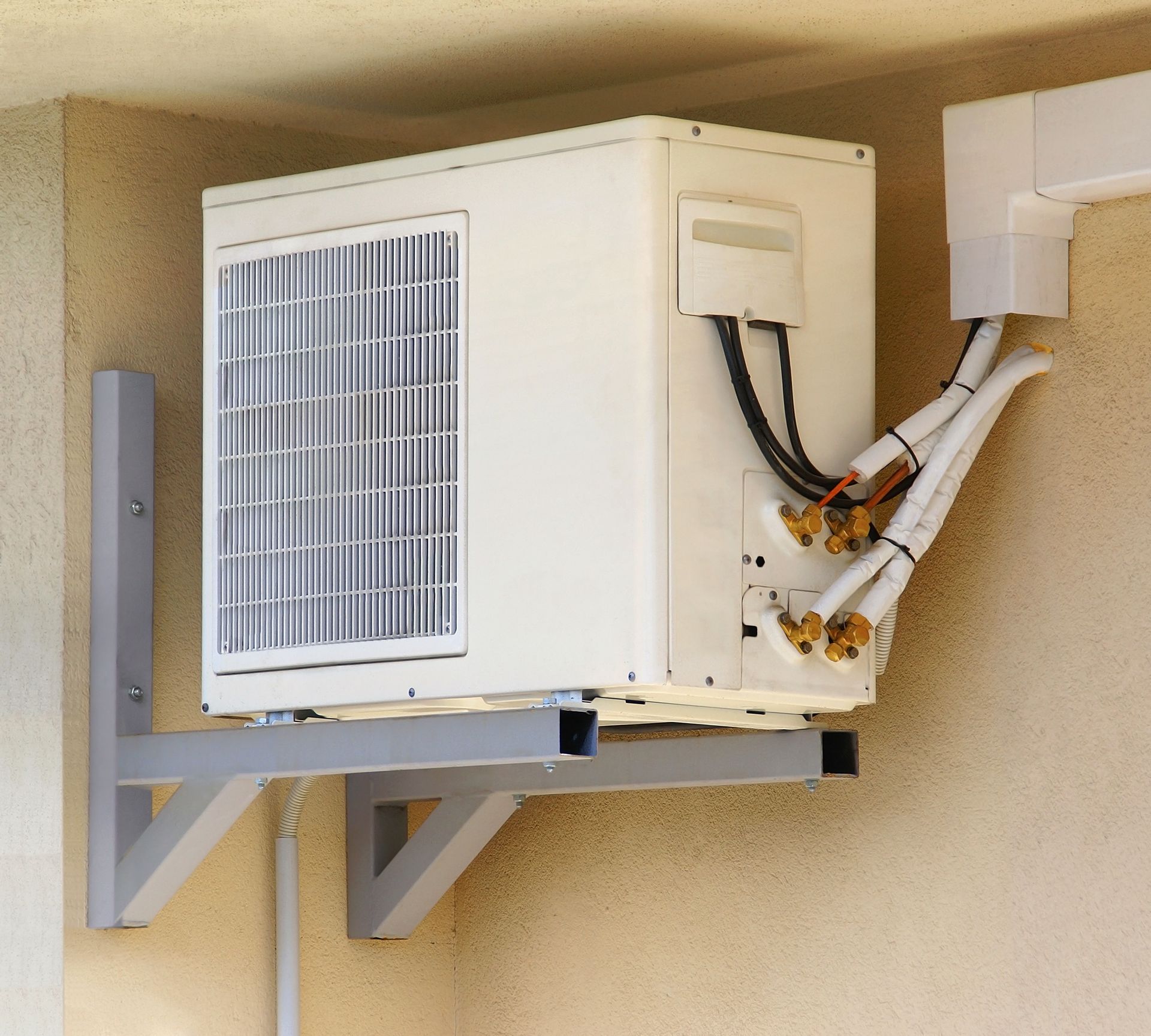 Une pompe à chaleur air-eau accrochée en hauteur contre un mur