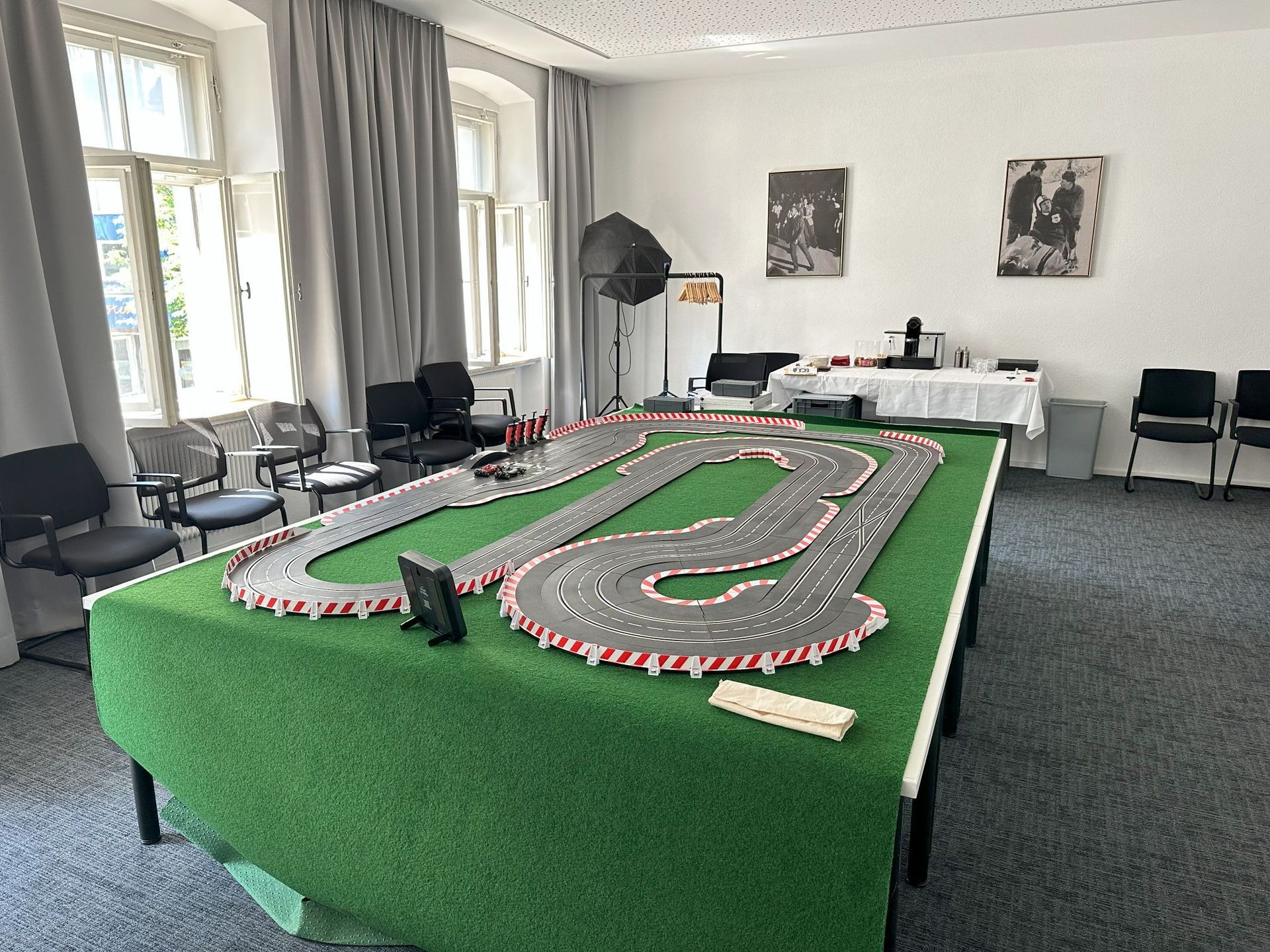 In einem Raum steht auf einem Tisch eine Spielzeug-Rennbahn.