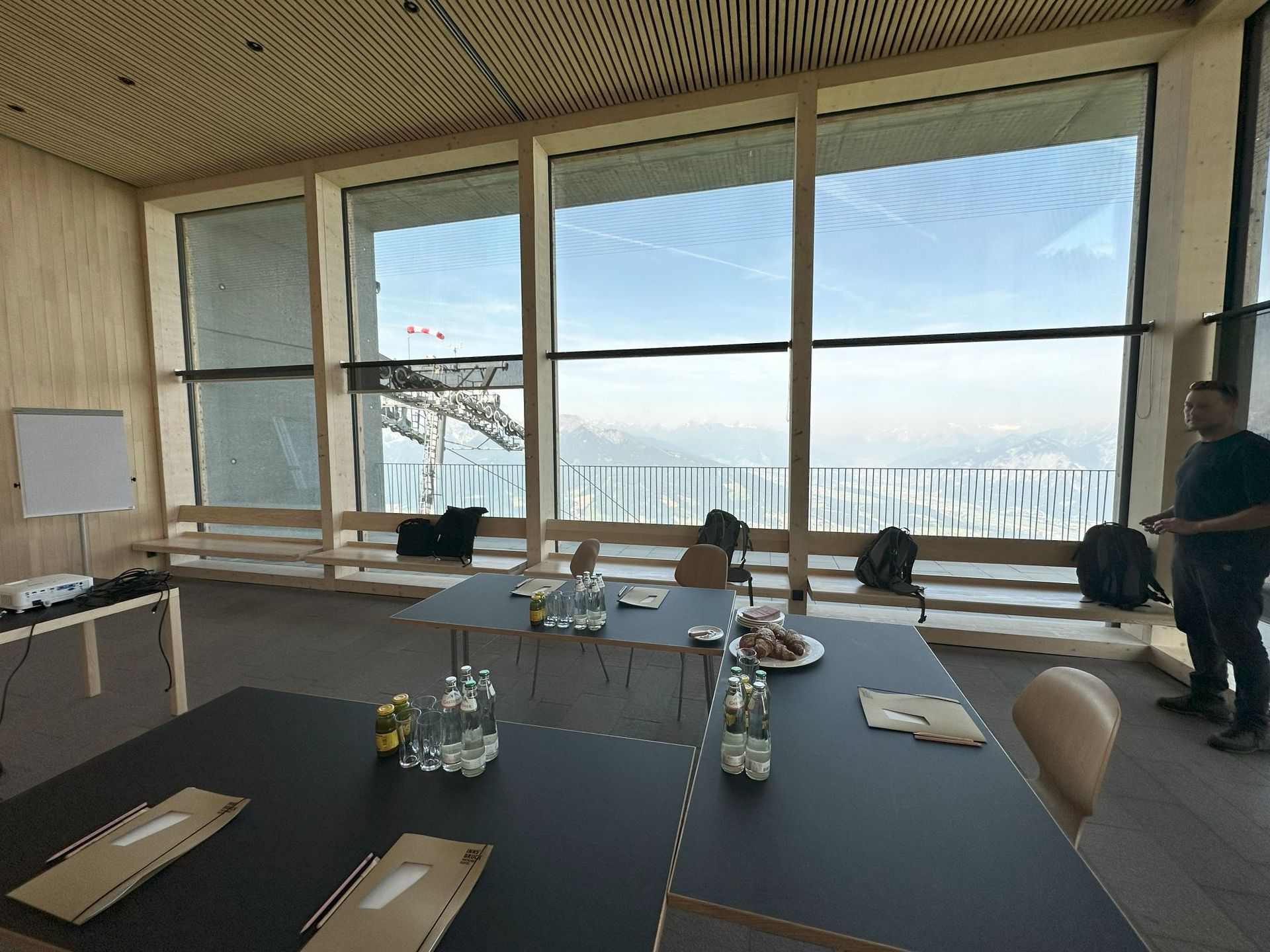 Ein Mann steht vor einem großen Fenster in einem Konferenzraum.