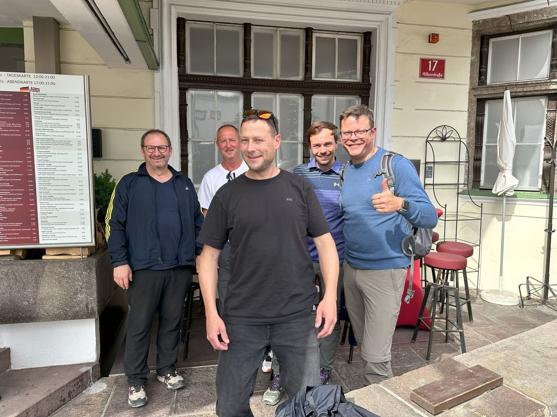 Eine Gruppe Männer posiert vor einem Gebäude für ein Foto.