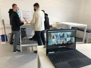 Eine Gruppe von Leuten führt über einen Laptop einen Videoanruf durch.