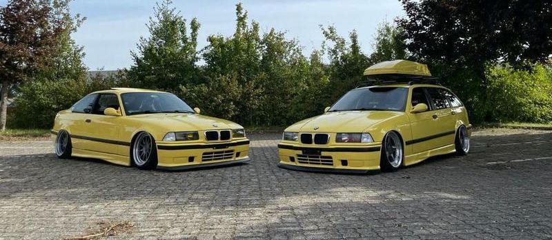 Zwei gelbe Autos parken nebeneinander auf einer Ziegelsteinstraße.