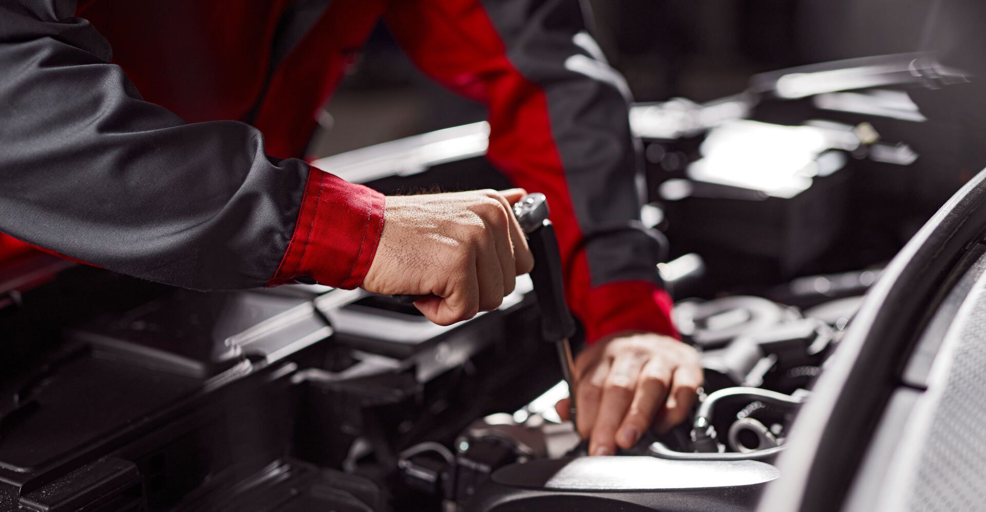 Ein Mechaniker arbeitet am Motor eines Autos.
