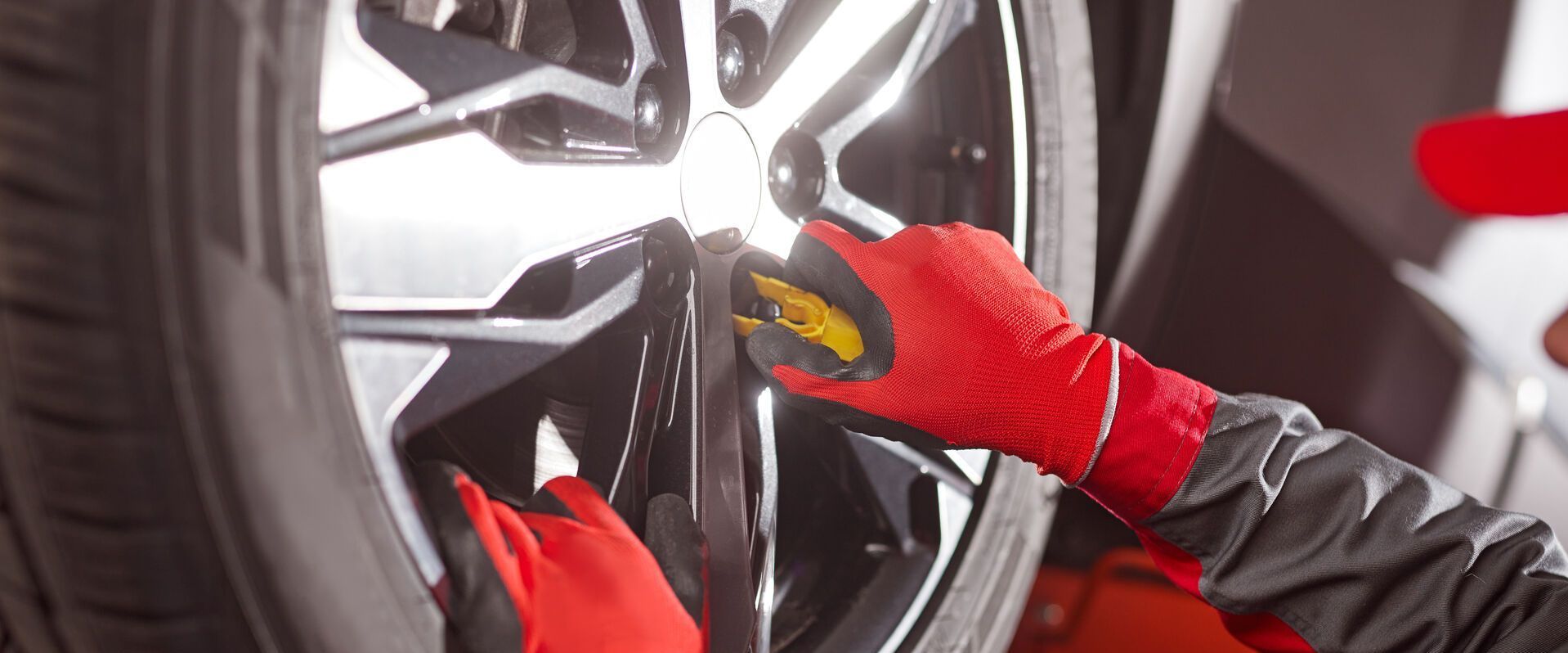 Eine Person mit roten Handschuhen arbeitet an einem Autorad.