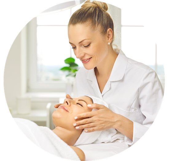 Esthéticienne faisant un massage du visage à une femme.