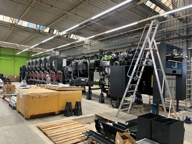 Un gran almacén lleno de mucha maquinaria y cajas.