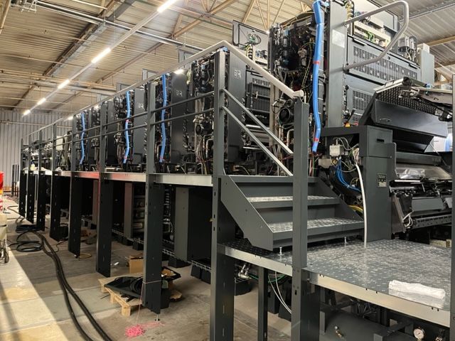 Una gran máquina de impresión se encuentra en un almacén.