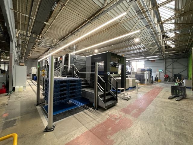 Un gran almacén lleno de mucha maquinaria y escaleras.