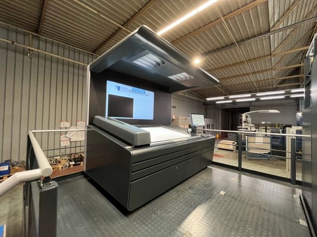 Una máquina grande en un almacén con un monitor encima.