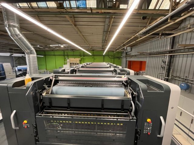 Una gran máquina de impresión se encuentra en un almacén.