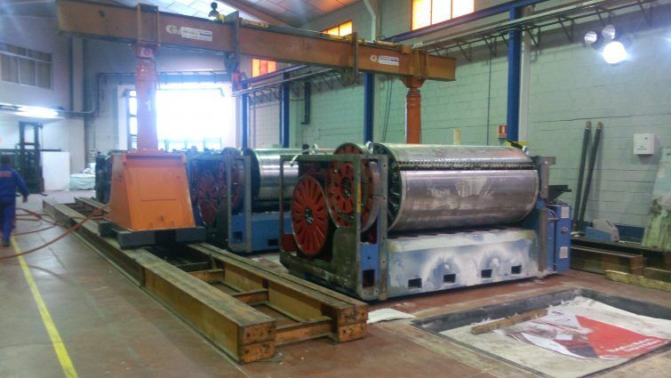 Una gran máquina está colocada encima de una paleta de madera en una fábrica.