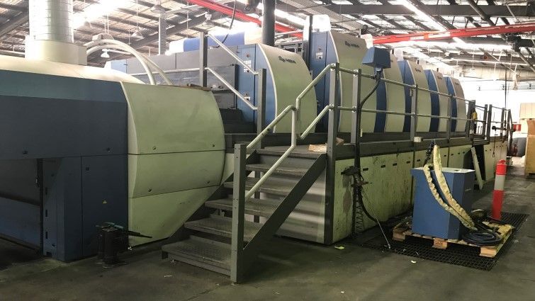 Una máquina grande en una fábrica con escaleras que conducen a ella.