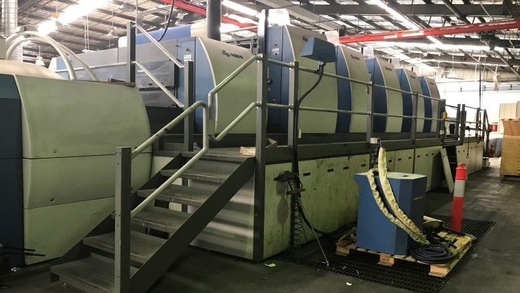 Una máquina grande se encuentra en un almacén con escaleras que conducen a ella.