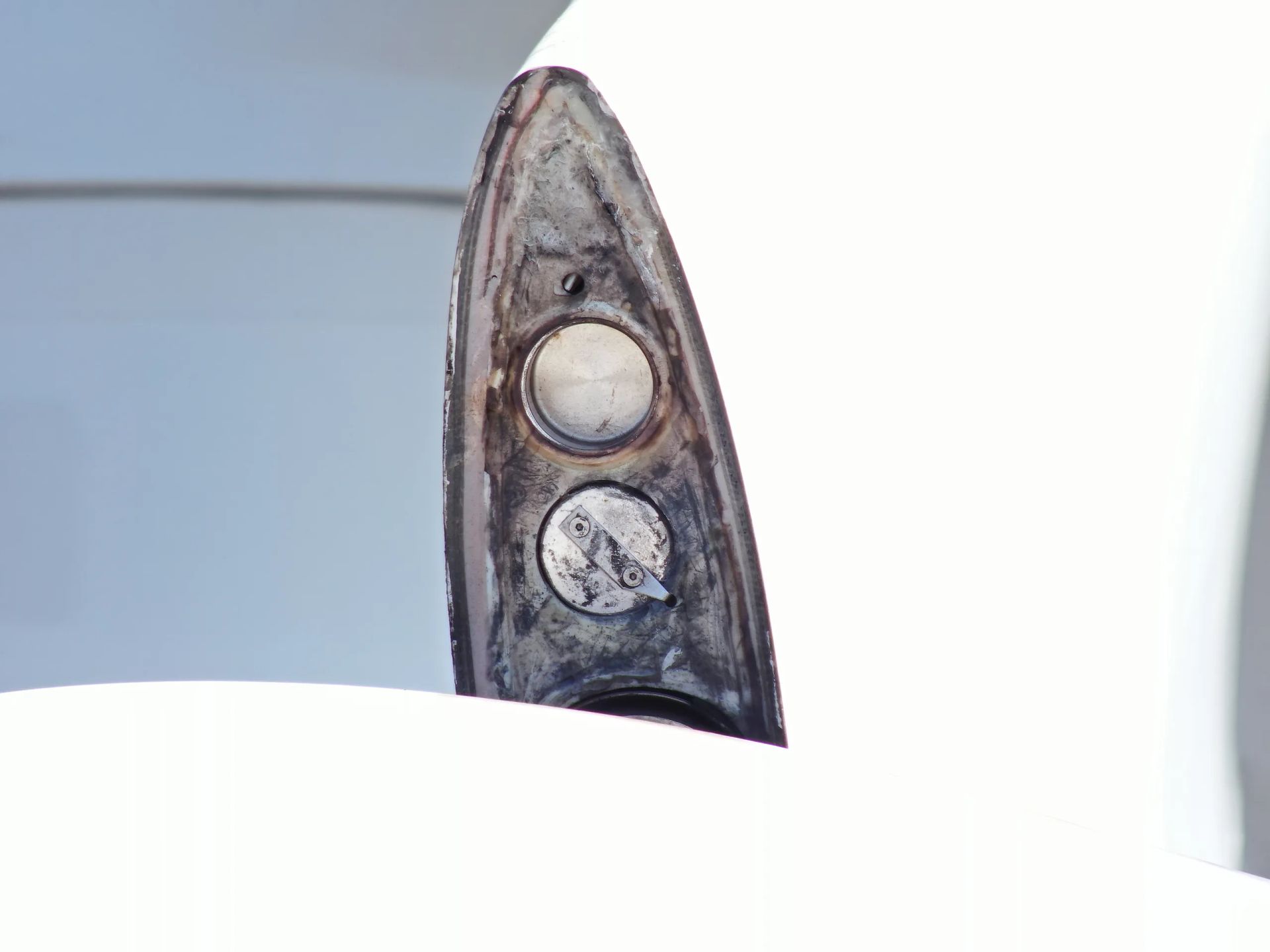 Un primer plano de un trozo de metal sobre una superficie blanca.