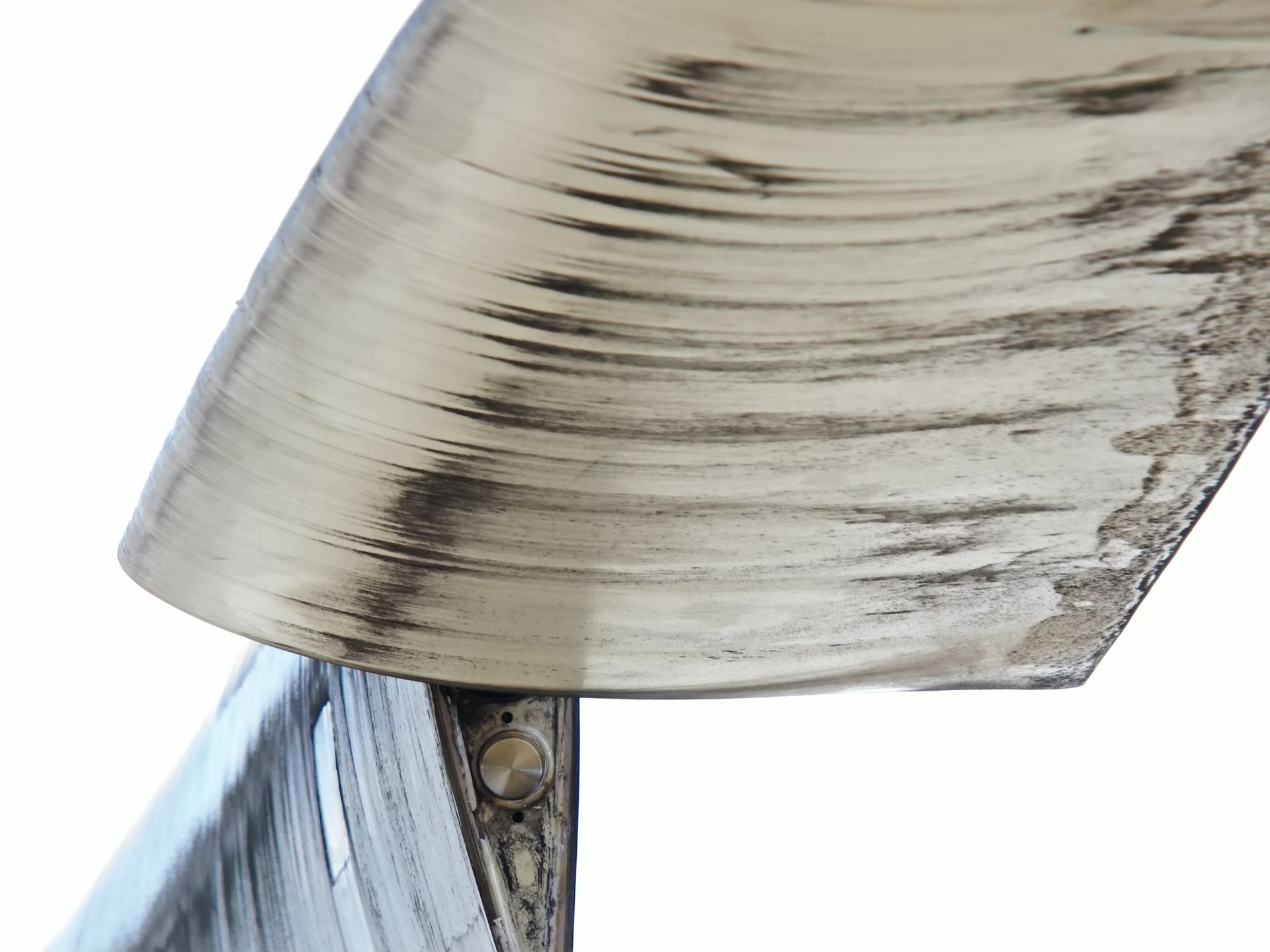 Un primer plano de un objeto metálico con un fondo blanco.