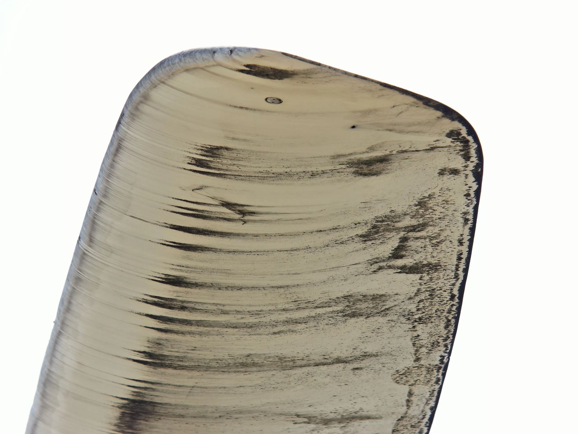 Un primer plano de un trozo de madera sobre un fondo blanco.