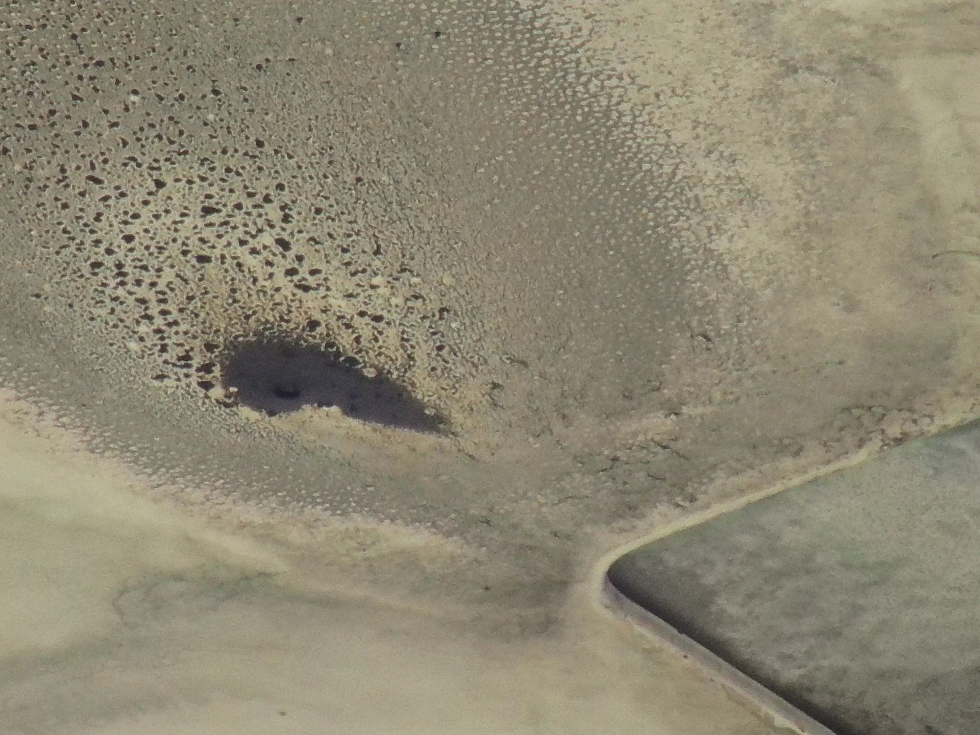 Una vista aérea de un paisaje desértico con un pequeño lago en el medio.