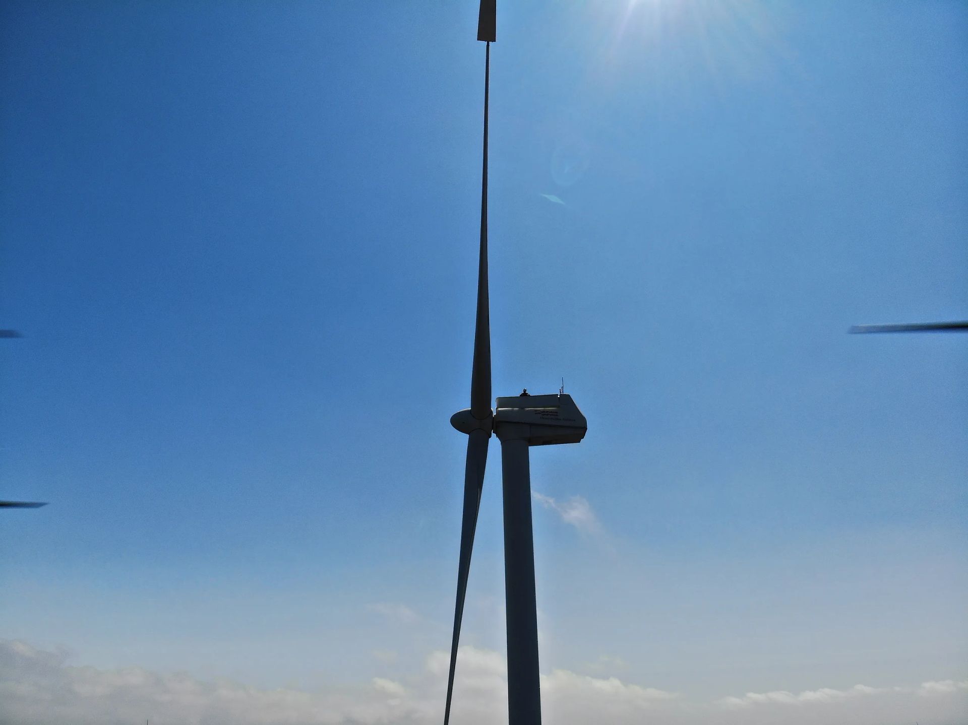 Un aerogenerador con un cielo azul al fondo
