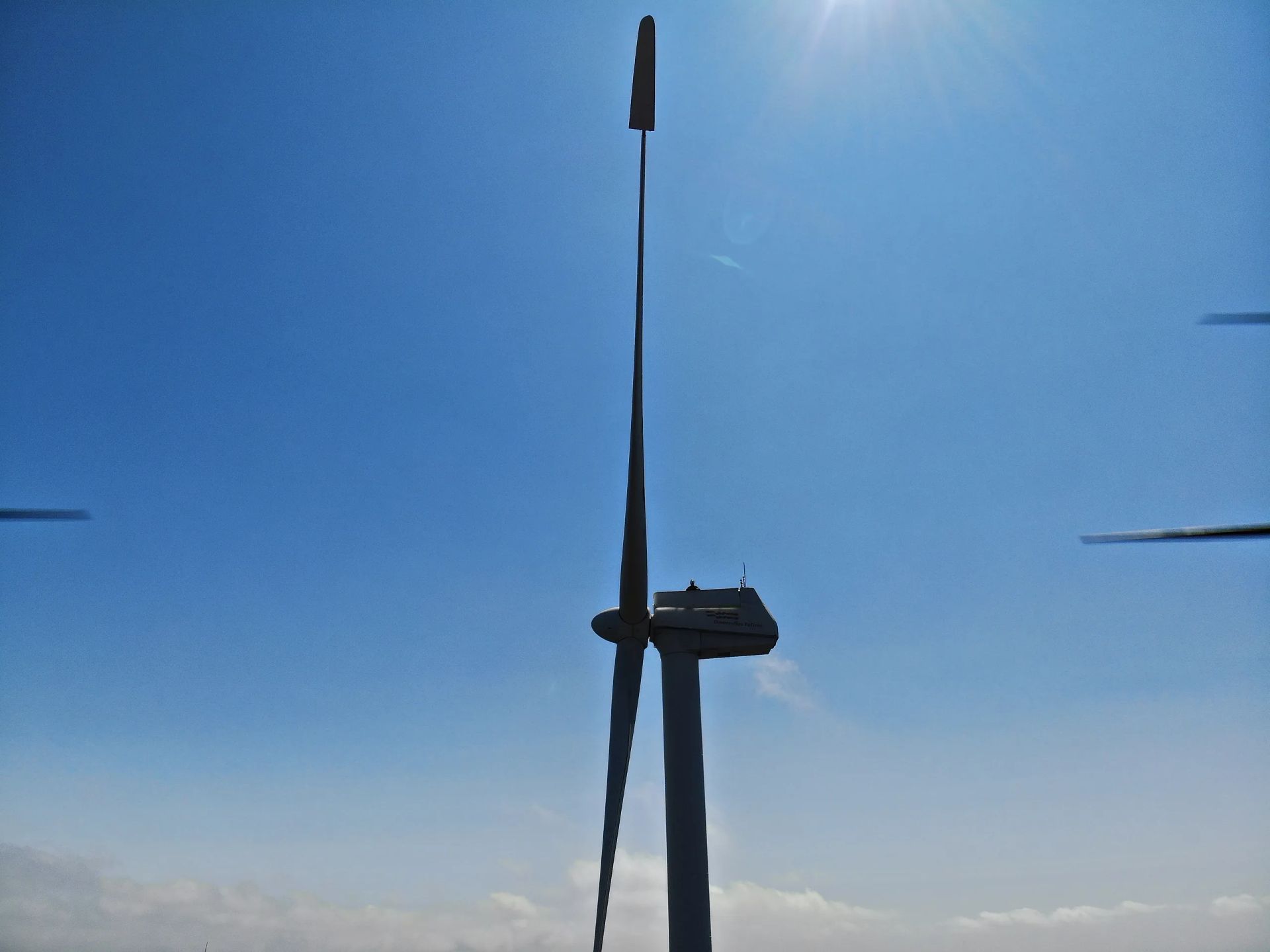 Una turbina eólica se recorta contra un cielo azul