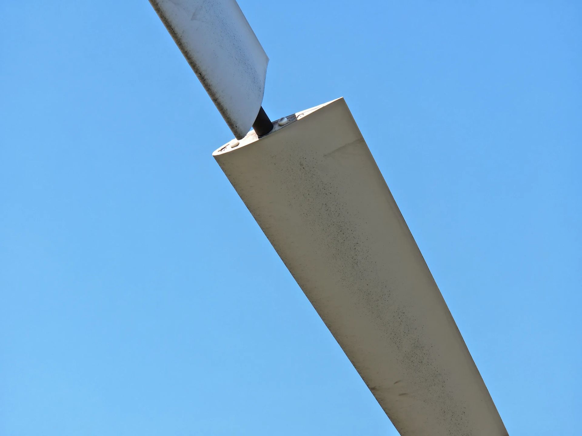 Un primer plano de una pieza de metal contra un cielo azul.