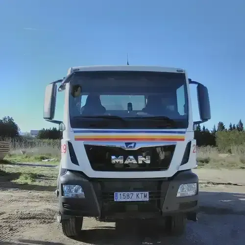 Un camión de carga está estacionado al costado de la carretera.