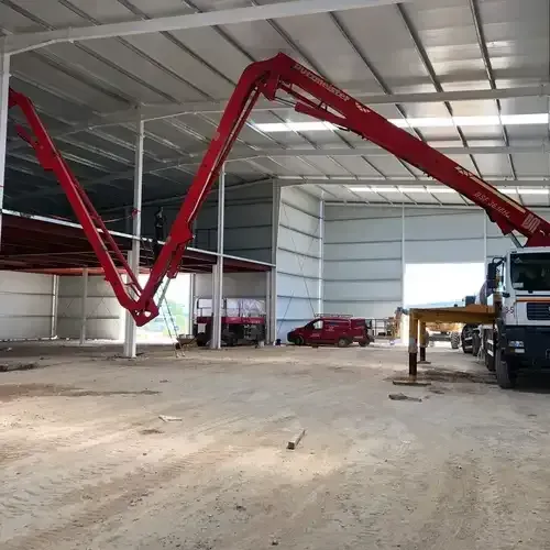 Un gran almacén con una grúa roja en el medio.