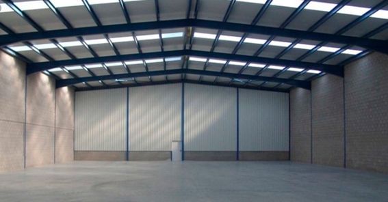 Un almacén vacío con techo azul y paredes blancas.