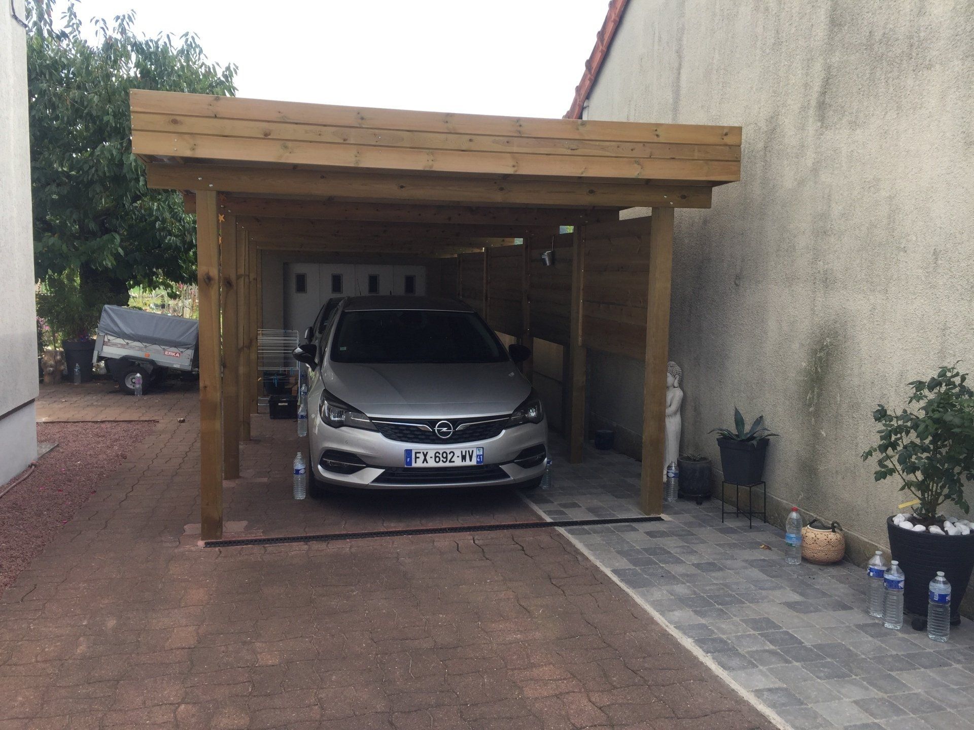 Abri d’auto en bois avec voiture grise