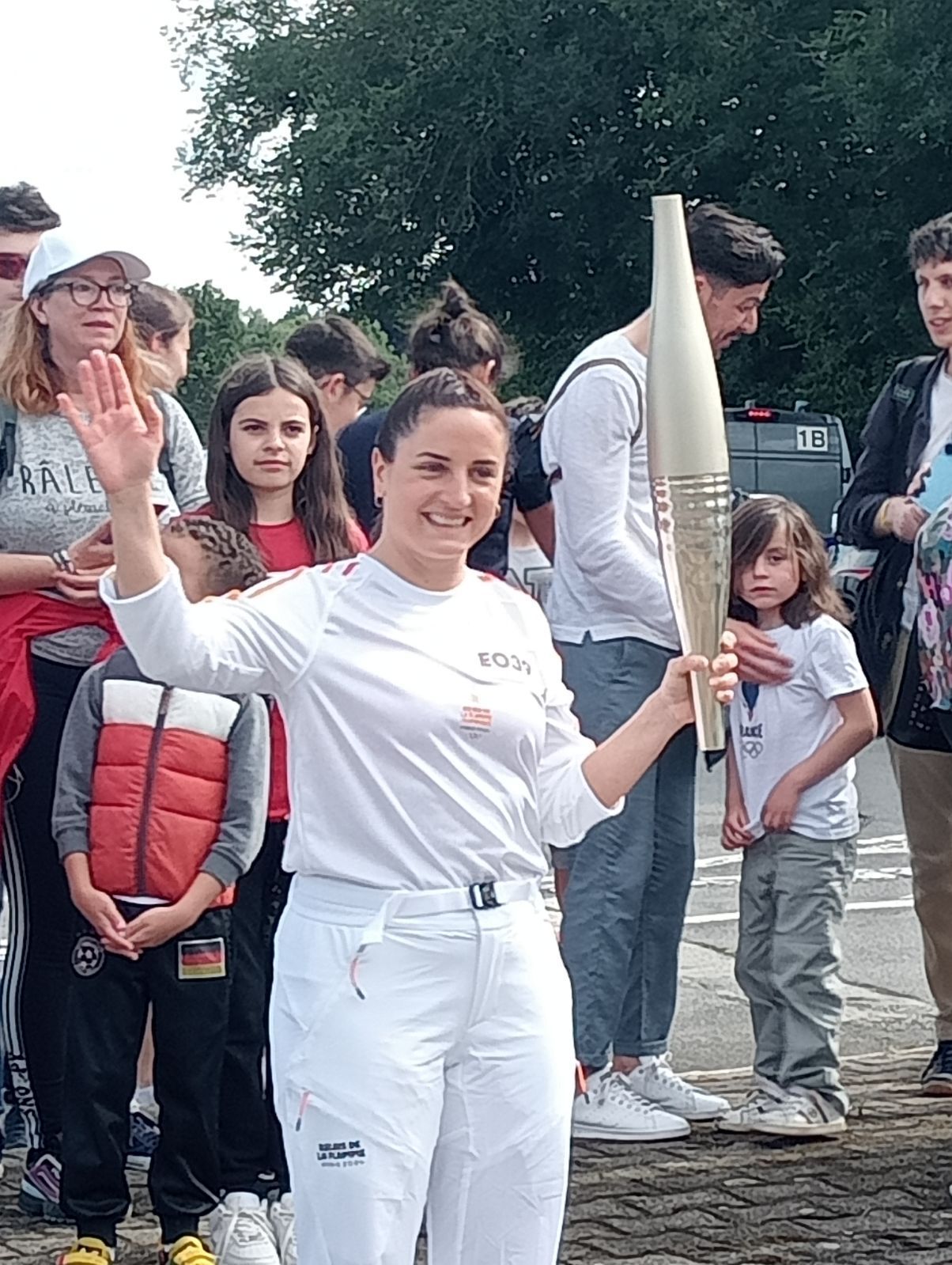Jeune femme en blanc tenant la flamme olympique
