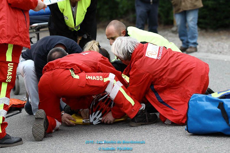Secouristes au dessus d'un blessé avec un casque de vélo