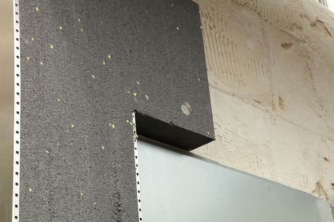 Gros plan sur des panneaux isolants en graphite gris installés sur un mur