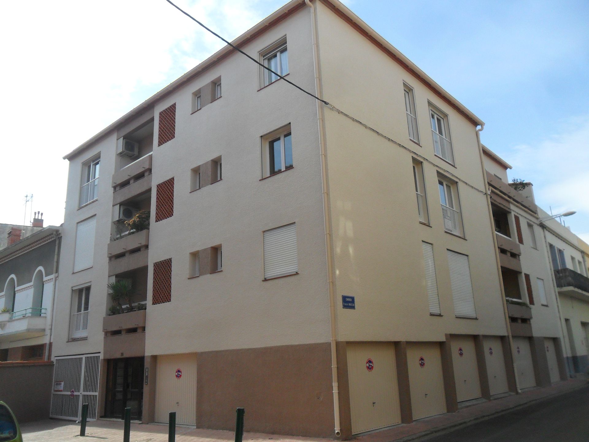 Un immeuble d'appartements de quatre étages avec des murs en stuc beige