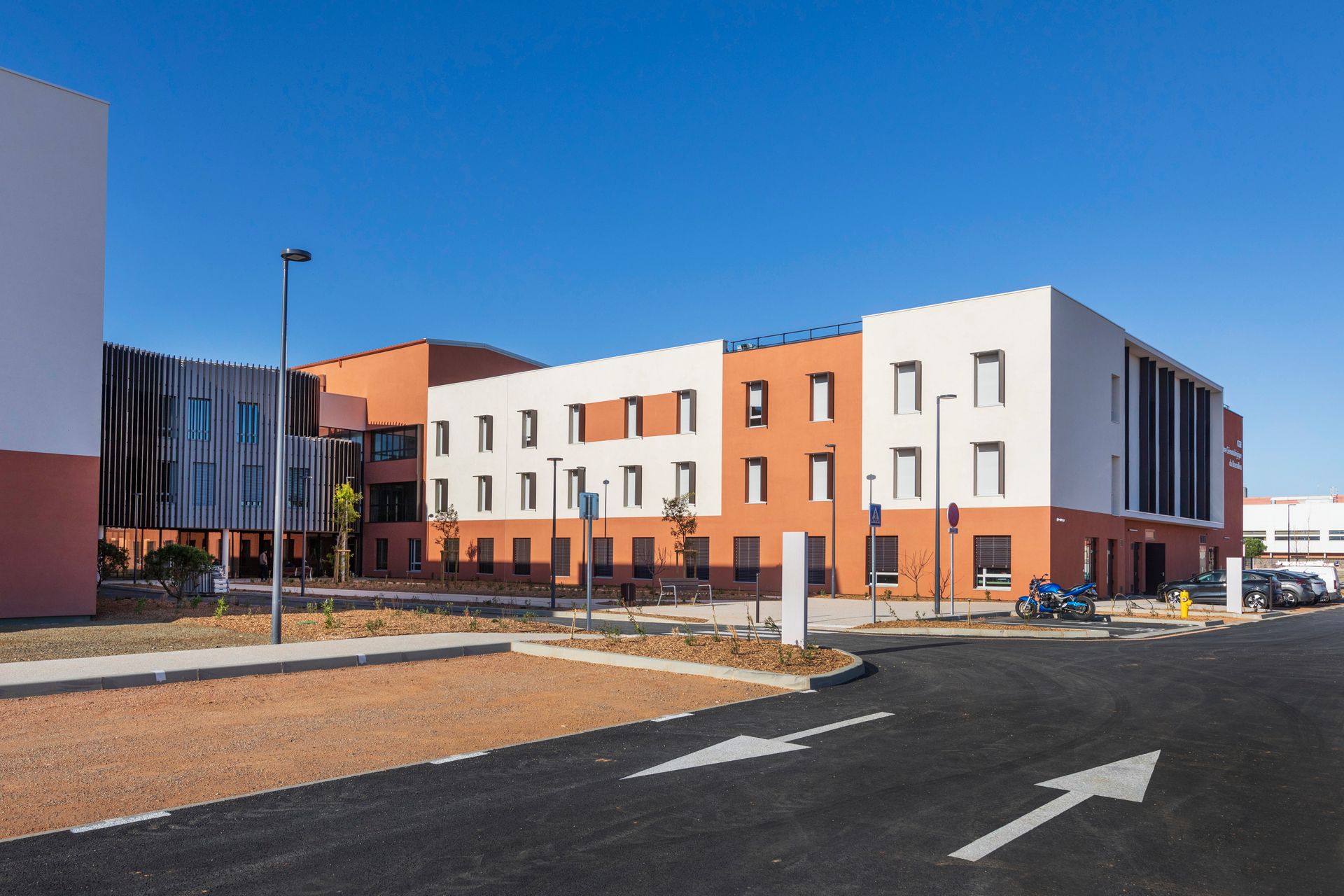 Immeuble moderne à plusieurs étages avec une façade blanche et orange.