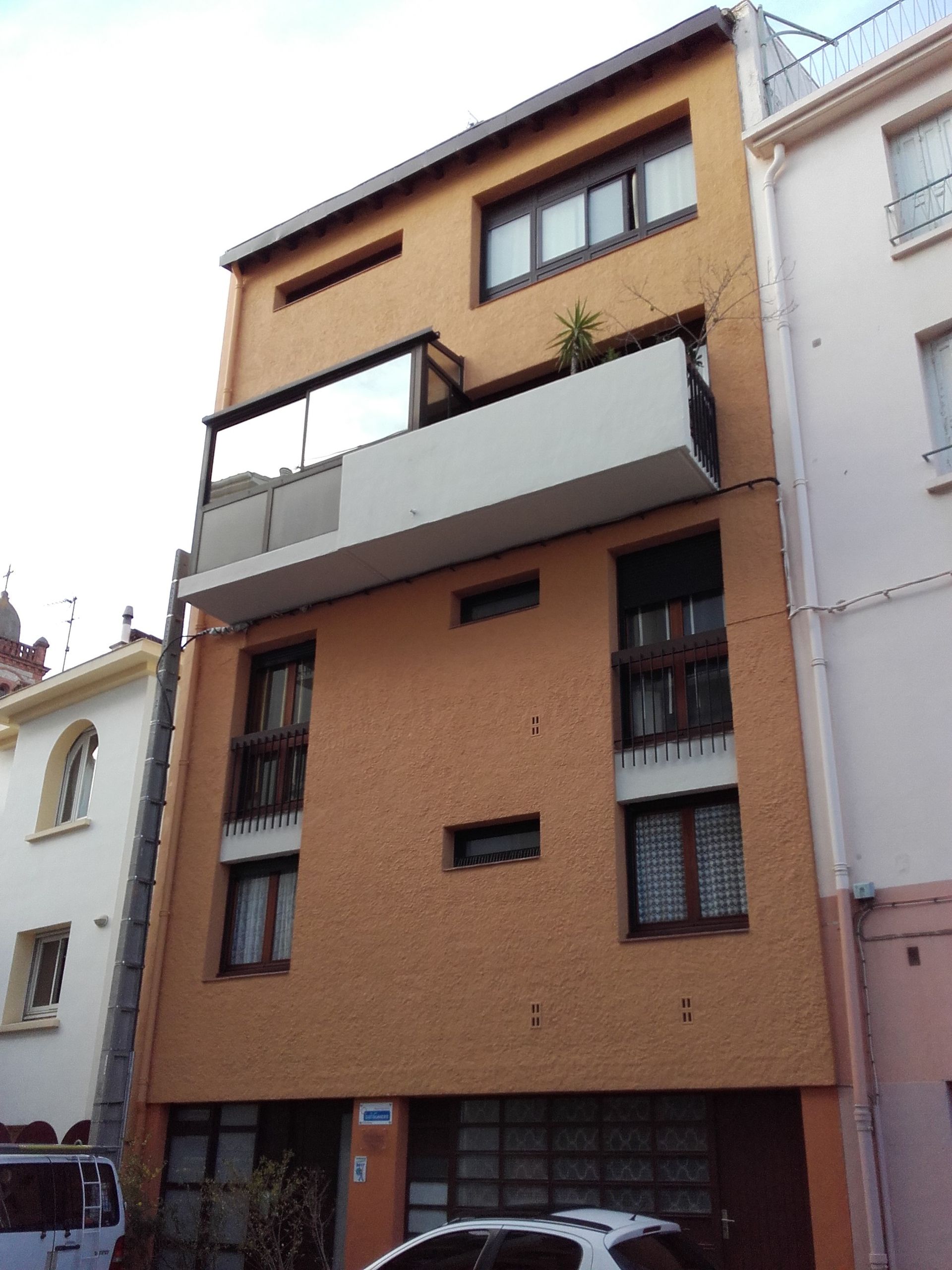 Un immeuble d'appartements de quatre étages, de couleur pêche