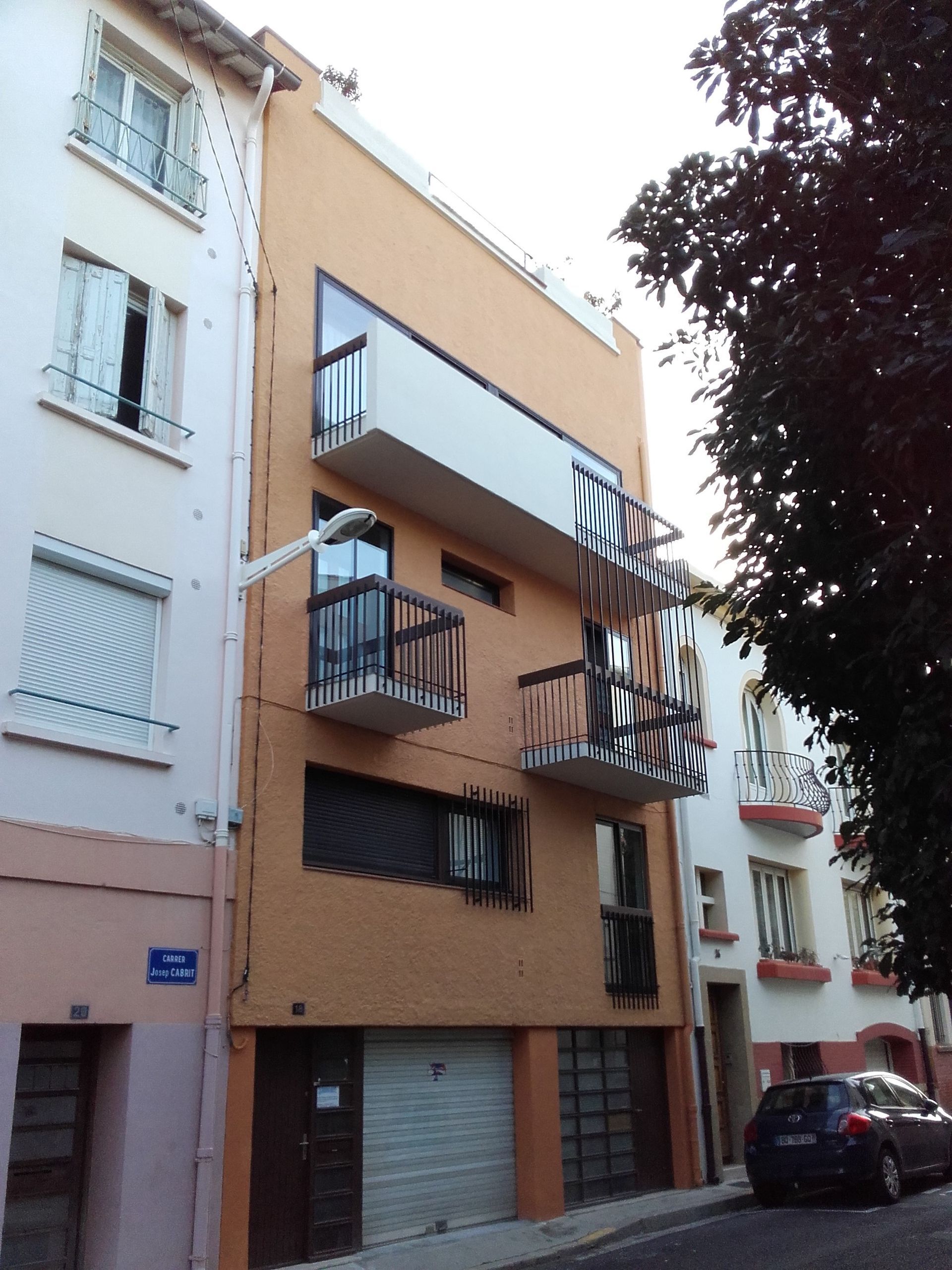 Un immeuble d'appartements moderne, de couleur beige, avec des balcons